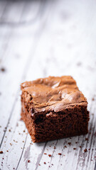 Chocolate chip brownies on a wooden background with crumbs around. Selective focus.