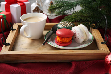Different decorated Christmas macarons served with coffee on table