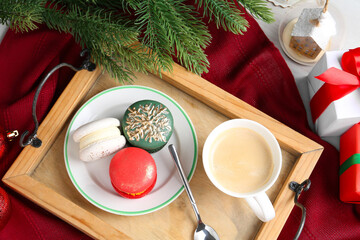 Different decorated Christmas macarons served with coffee on table, flat lay