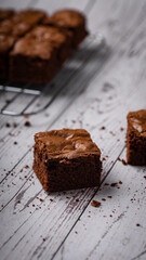 Chocolate chip brownies on a wooden background with crumbs around. Selective focus.