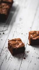 Chocolate chip brownies on a wooden background with crumbs around. Selective focus.