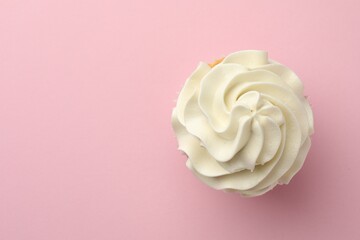 Tasty vanilla cupcake with cream on pink background, top view. Space for text