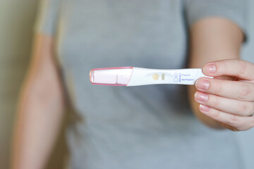 Close up of a woman holding a negative pregnancy test