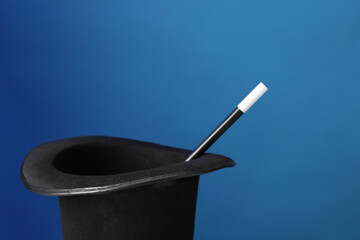 Magician's hat and wand on blue background