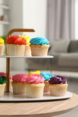 Delicious cupcakes with bright cream on wooden table indoors