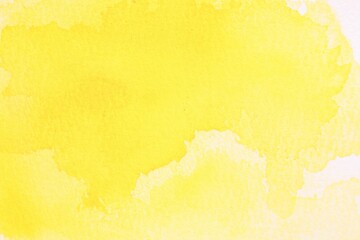 Abstract yellow watercolor painting on white paper, top view