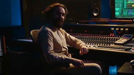 Sound engineer mixing and mastering tracks in professional recording studio, working with daw...