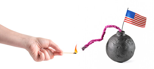 Hand holding a lit match and about to light a black bomb fuse with a US American flag. USA bomb...