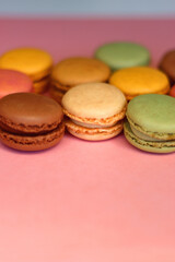 Colorful macarons on pink background. Selective focus.
