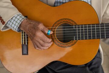 details of stringed musical instrument, hands of a person with musical chords on guitar. lifestyle and music background
