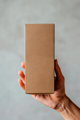 a hand holding an unlabeled cardboard box or packaging