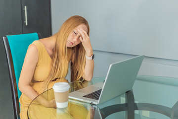 Tired pregnant woman at work drinks coffee caution advised due to potential harm of caffeine during...