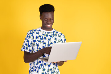 A man is smiling while using a laptop