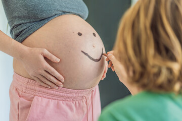 Adorable moment as a son adds a touch of joy to his mother's pregnancy, playfully drawing a funny...
