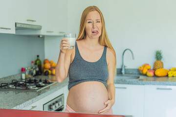 Weighing the pros and cons of milk during pregnancy, a thoughtful pregnant woman stands in the...