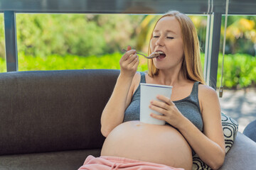 Happy pregnant young woman eating ice cream