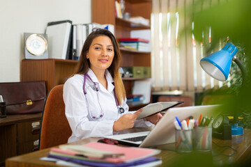 Young woman healthcare worker working in medical office using laptop computer
