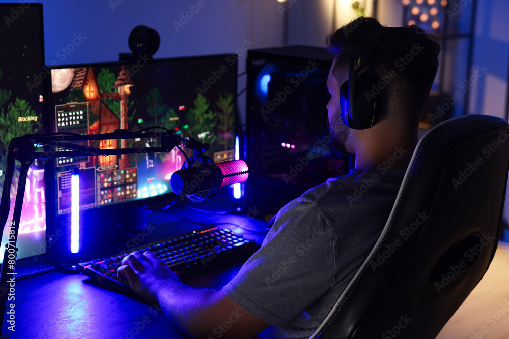 Wall mural man playing video games on computer at table indoors