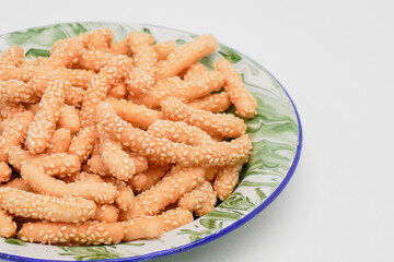 A dry snack made from flour and sesame in an oval shape is called keciput