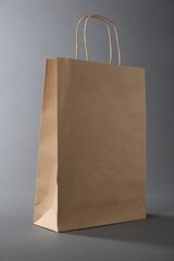 One kraft paper bag on grey background. Mockup for design