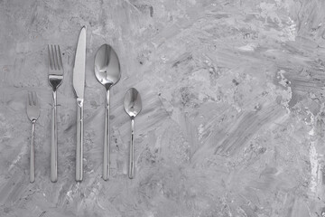 Beautiful cutlery set on grey table, flat lay. Space for text