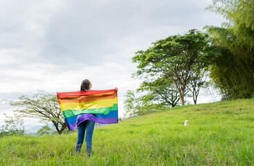 joven mujer lesbiana al aire libre con la bandera del orgullo gay 