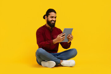 Indian Man Sitting on Floor Using Tablet