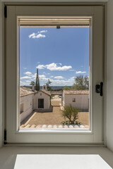 a window looking out onto a country house with its own catholic chapel