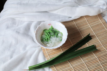 Lod Chong, made from green rice flour jelly on top palm sugar syrup on table. Traditional Thai dessert.