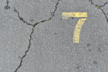 The number seven painted on cracked pavement.