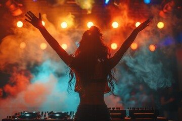 A woman is standing in front of a DJ booth, surrounded by colorful lights