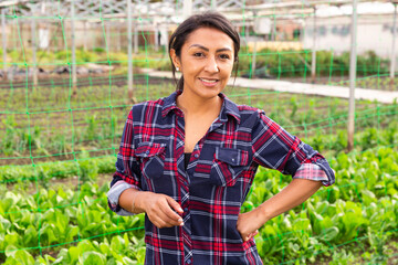 Happy middle aged latin american woman farmer smiling at vegetable plant factory