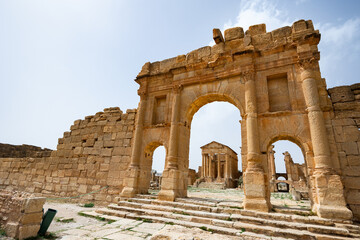 Magnificent triple-arched Antonine Gate opening onto a large paved forum with chopped-off columns...