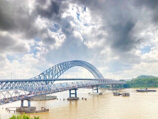 The view of Mahakam Bridge in East Kalimantan with the river and cloudy sky