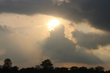 Sky blue and orange light of the sun through the clouds in the sky