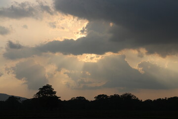 Sky blue and orange light of the sun through the clouds in the sky
