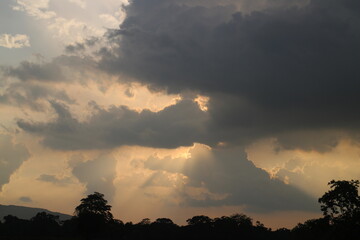 Sky blue and orange light of the sun through the clouds in the sky
