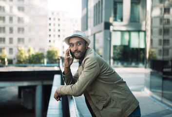 A young black man is talking on the phone, next to a business center.