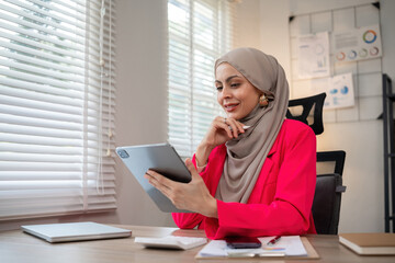 Confident Muslim businesswoman supervisor checks work on holiday and works in home office