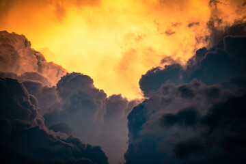Close-up shot of black clouds and orange clouds reflecting sunlight at dusk. Dramatic sky.