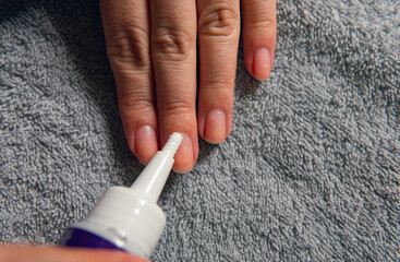 horizontal photo of hands using cuticle remover