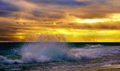 A large wave break close-up against a sunset