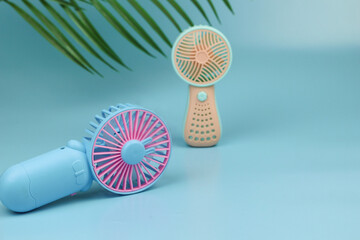 Kipas angin mini or pertable mini fan with pastel color. Isolated blue background.