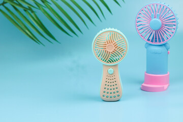 Kipas angin mini or pertable mini fan with pastel color. Isolated blue background.