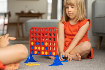 Cute little girl strategizing in Connect Four. Logic game