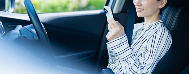 車内で携帯を持つ日本人女性
