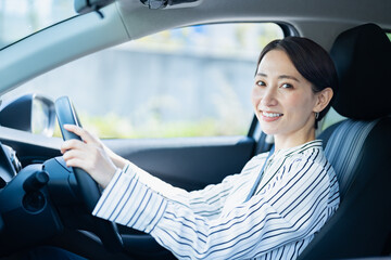 車を運転する私服の日本人女性