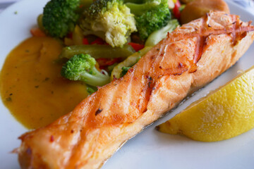  grill salmon served with fresh vegetables on a plate 