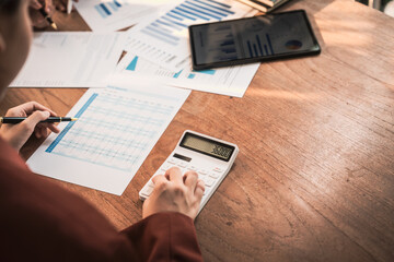Diverse group of professionals businesswomen gather in meeting room for collaborative discussions on finance, strategy, and teamwork, technology tablets and laptops for data analysis and presentation