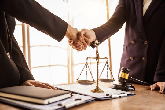 Shaking hands, Lawyers offer legal guidance, stand for clients in court, and aid with legal paperwork. analyze laws to safeguard clients' rights and interests, fair representation and justice.
